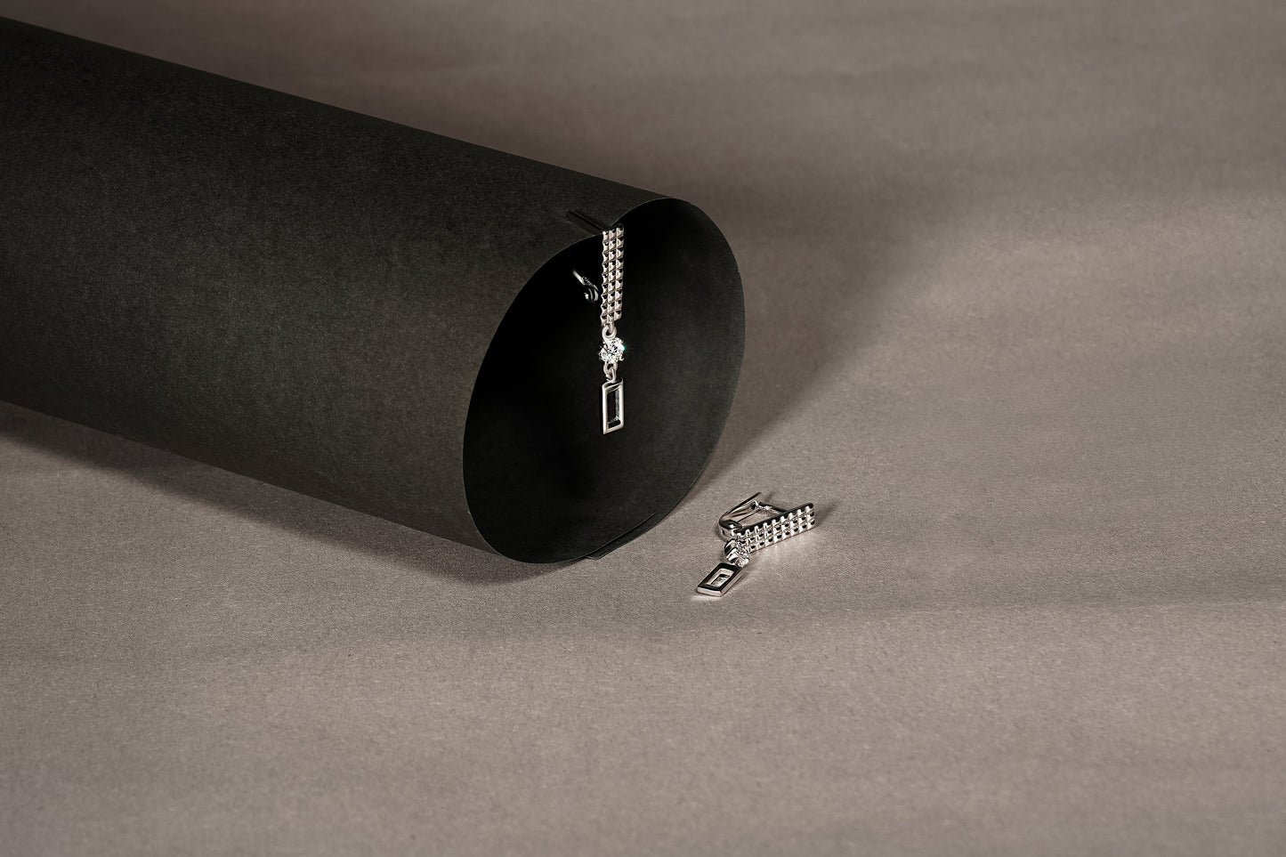 Сережки довгі з білого золота з діамантами та англійською застібкою. Зображені на сіро-чорному фоні