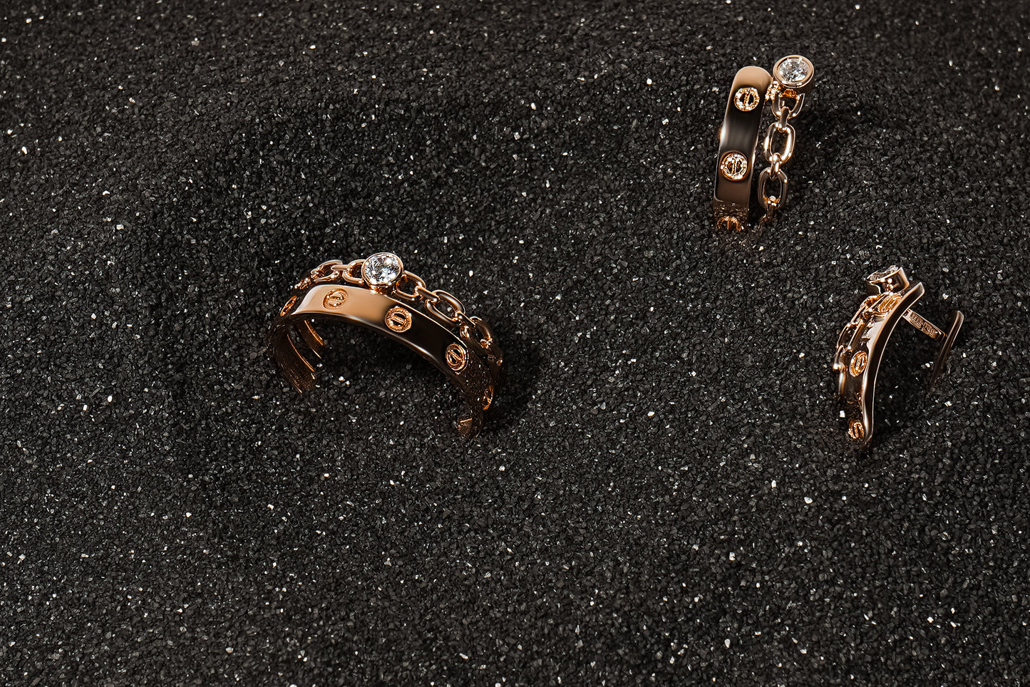 Набір каблучка і сережки з червоного золота на сірому піску