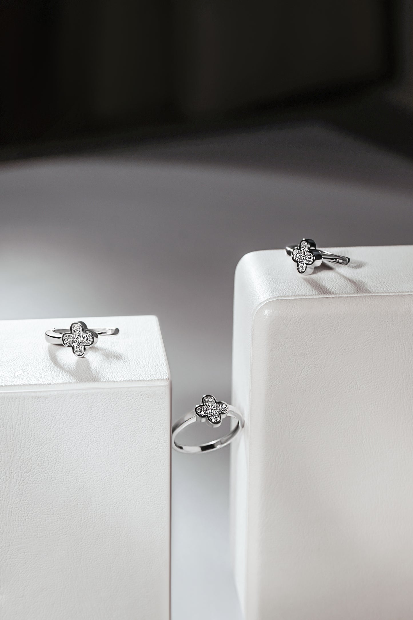 Сережки та каблучка з діамантами у фрмі хрестиків з англійською застібкою. Зображені на білих підставках