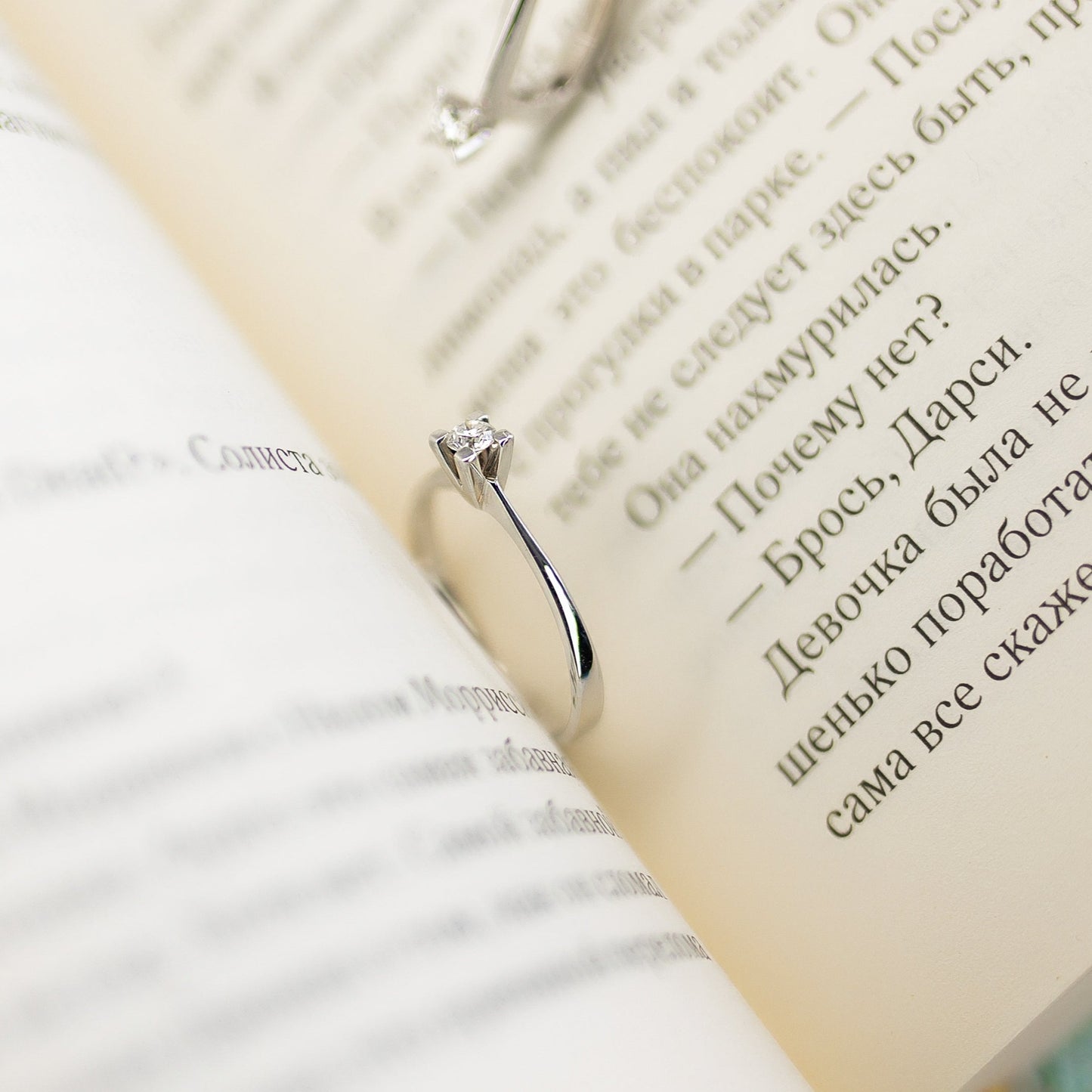 Каблучка з білого золота з маленьким діамантом зображена в книжці